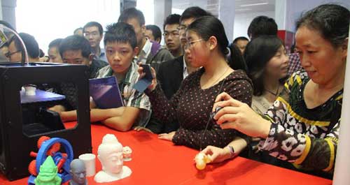 在某展会上，正在工作中的3D打印机吸引众多观众驻足观看。