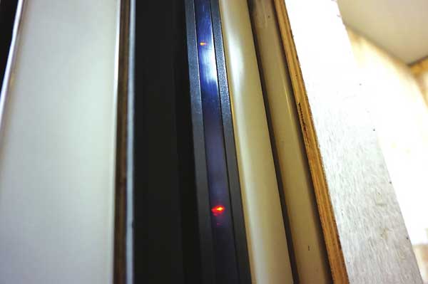 电梯门上的红点就是光膜感应，是几十个安全触点中的一个，用来防止人被门夹住。在电梯开关门时只用手挡在当中，让射线两端无法对准，门就始终关不上，假如电梯门发生轻微变形，就可导致光膜感应时好时坏，影响门的开关。