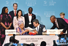 12月16日，在肯尼亞內羅畢，利比里亞總統埃倫·約翰遜-瑟利夫（前左）和世貿組織總干事羅伯托·阿澤維多（前中）互換簽署后的入世相關文件。世界貿易組織第十屆部長級會議16日在肯尼亞首都內羅畢通過協議，正式批準利比里亞加入世貿組織。