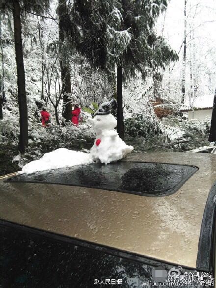 图为堆在车顶的雪人。