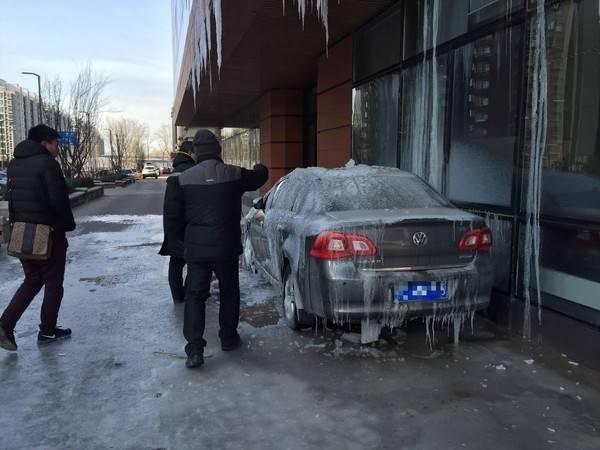 昨天上午，记者在顺义中建·国际城梅香街9号院18号楼前看到，结冰的轿车就停在18号楼前，车身上结着厚厚的冰，车上方的房檐处结着约半米长的冰柱，两名男士正在敲打着车身上的冰。