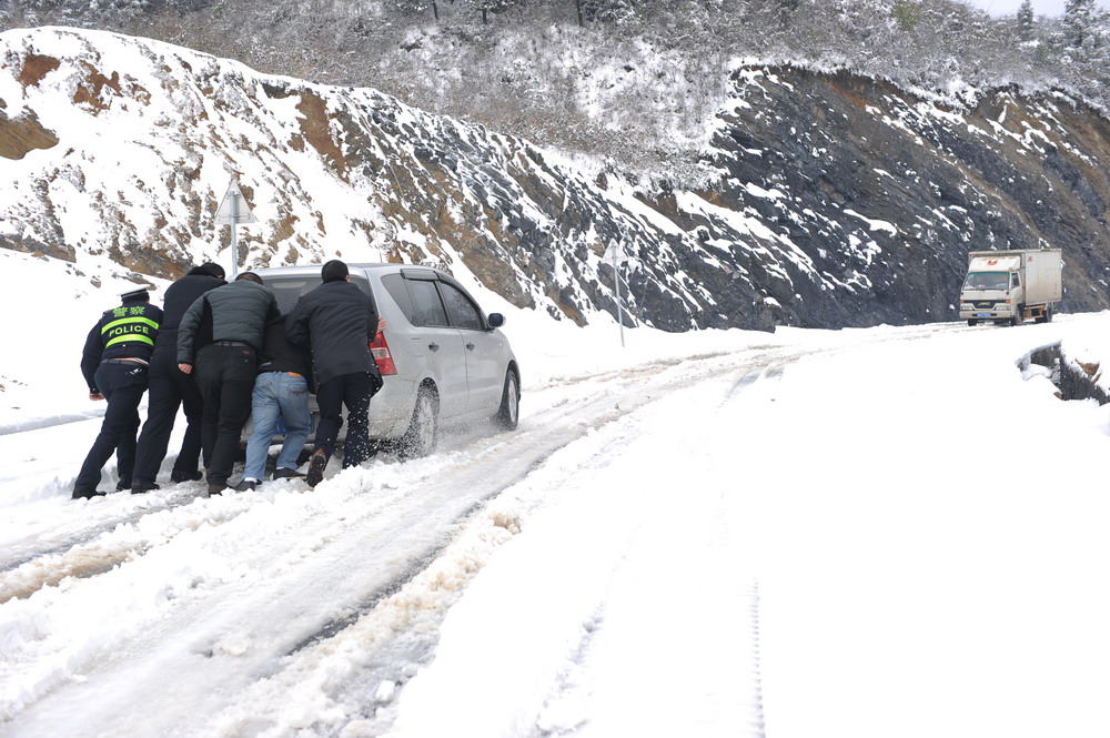 3月10日，贵州省松桃县乌罗镇癞子岭路段，松桃交警为打滑车辆推车。