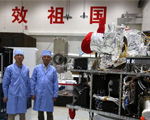 5月25日，在中国科学院上海微小卫星工程中心，量子科学实验卫星总设计师朱振才（左）与副总工程师周依林在量子卫星旁合影留念。新华社记者 才扬摄