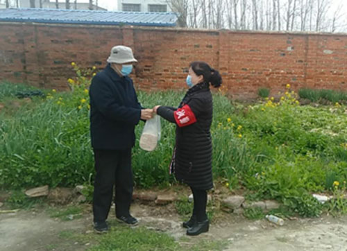 郭敬芬（右）为独居老人免费代购粮食